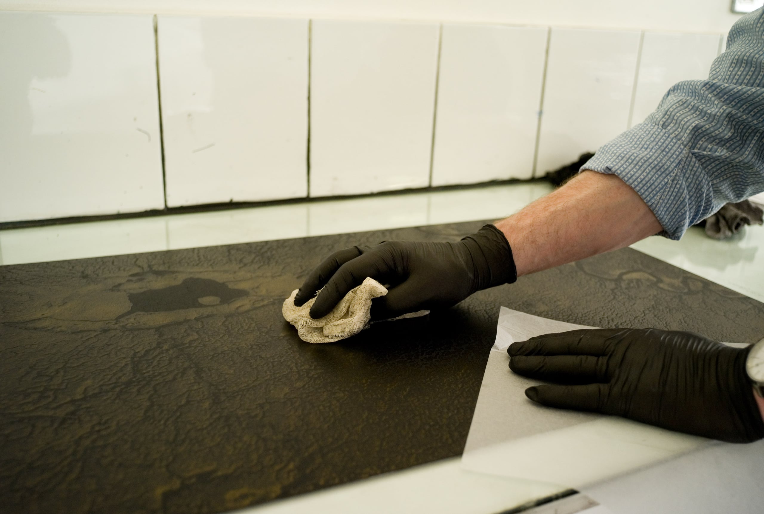 A man placing ink onto the polymer photogravure plate