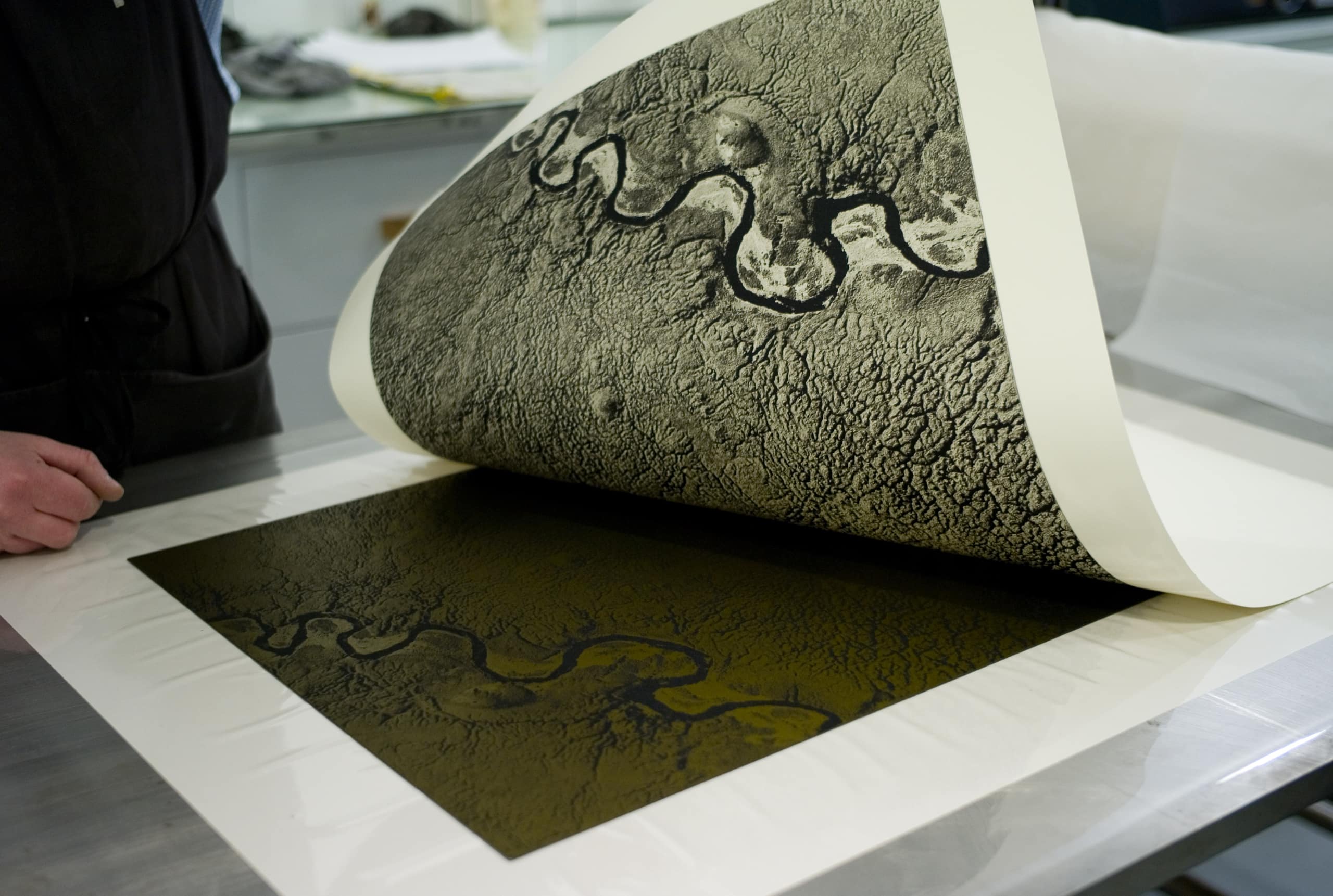 The finished polymer photogravure print being removed from plate, with the fresh print being exposed