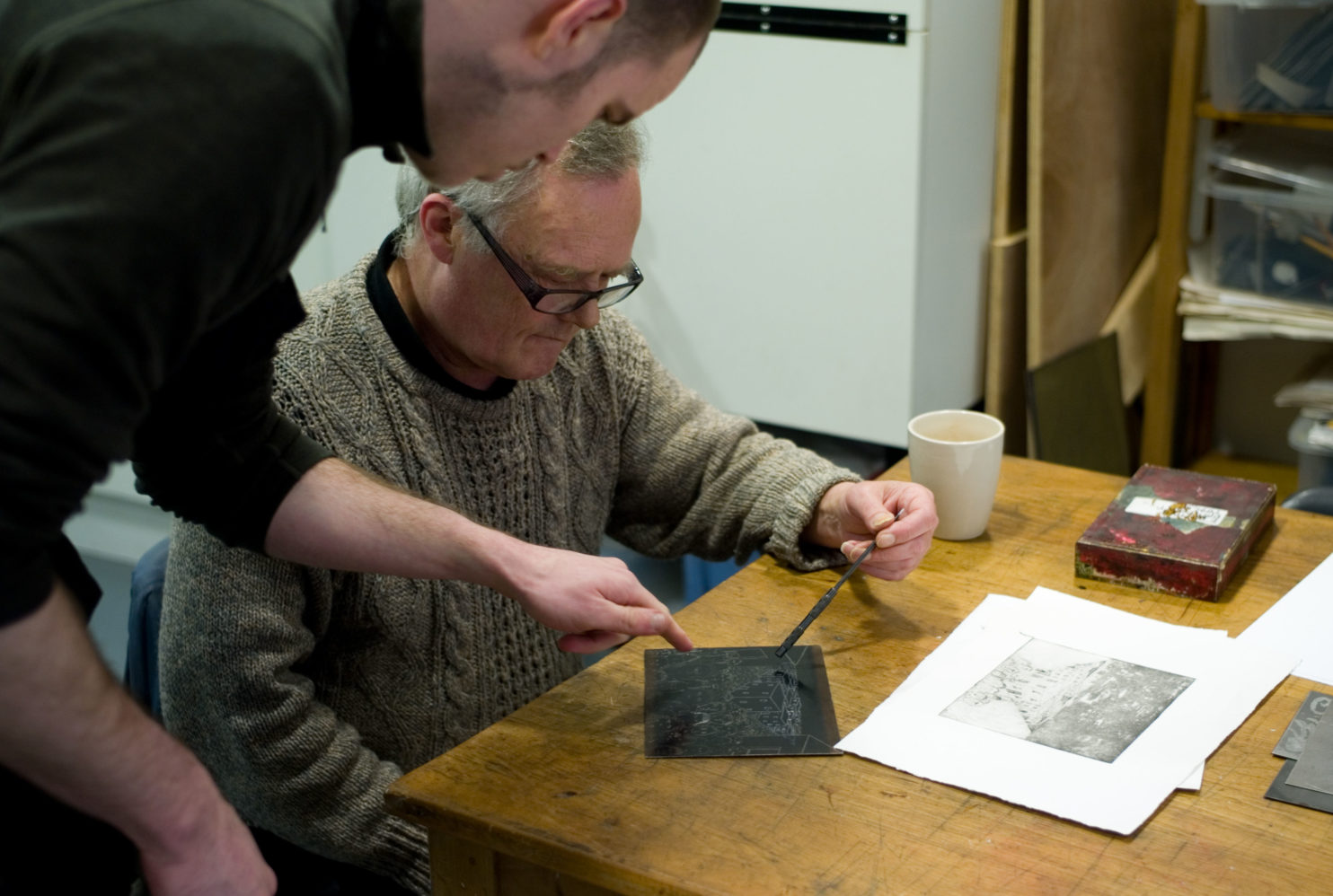 Teacher, teaching a student how to make a print