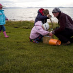 A adult and children next to the sea