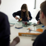 School children using a roller to create art