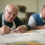 2 elderly men creating art
