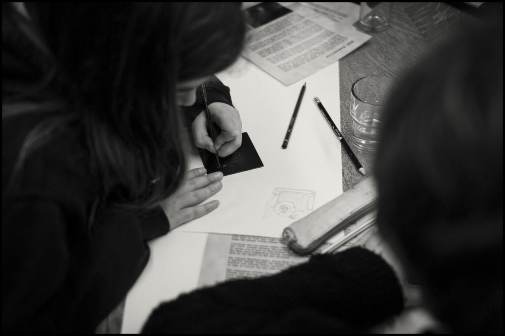 Students creating art around the table