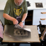 A person creating a print