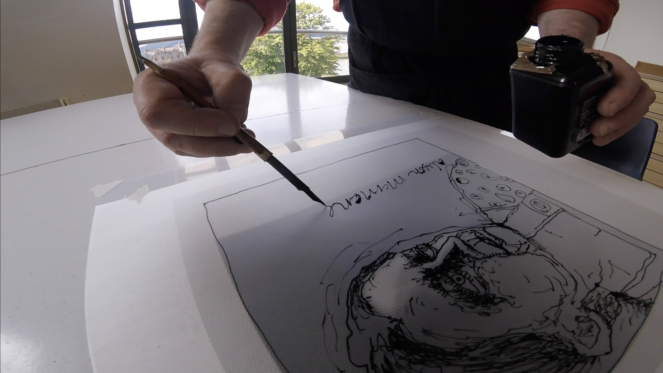 A man writing with a fountain pen on an illustration of a man's head