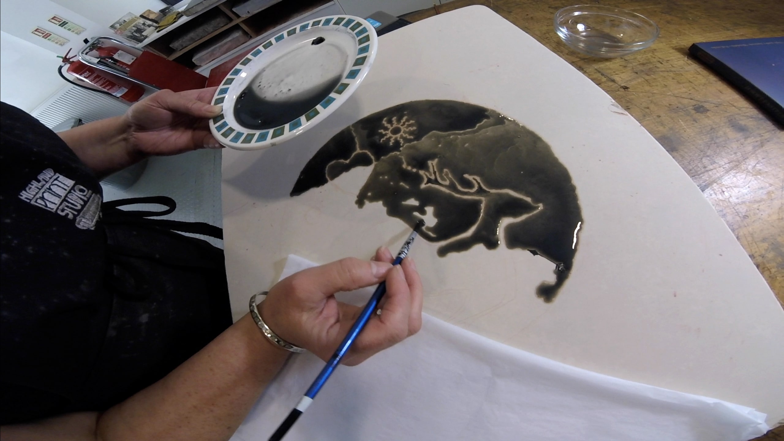 Stone Lithography taking place, with a person painting onto the stone with a grease-based paint