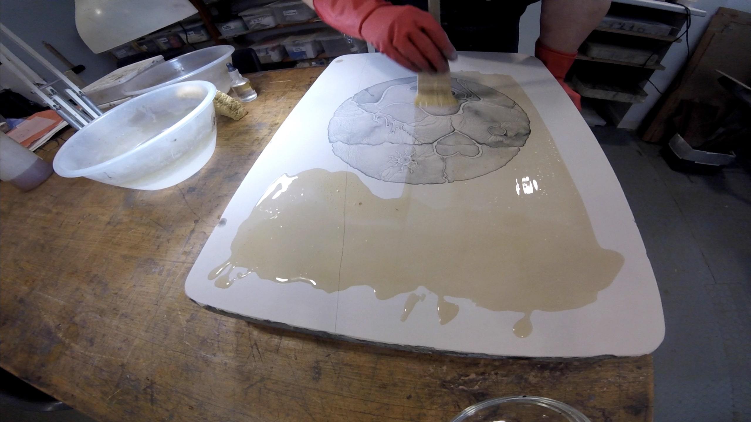 Stone Lithography taking place with a person painting an emulsion of nitric acid and gum arabic to harden this layer