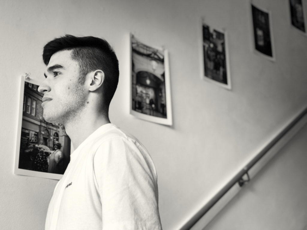 Black and white photo - A person on the stairs next to artwork